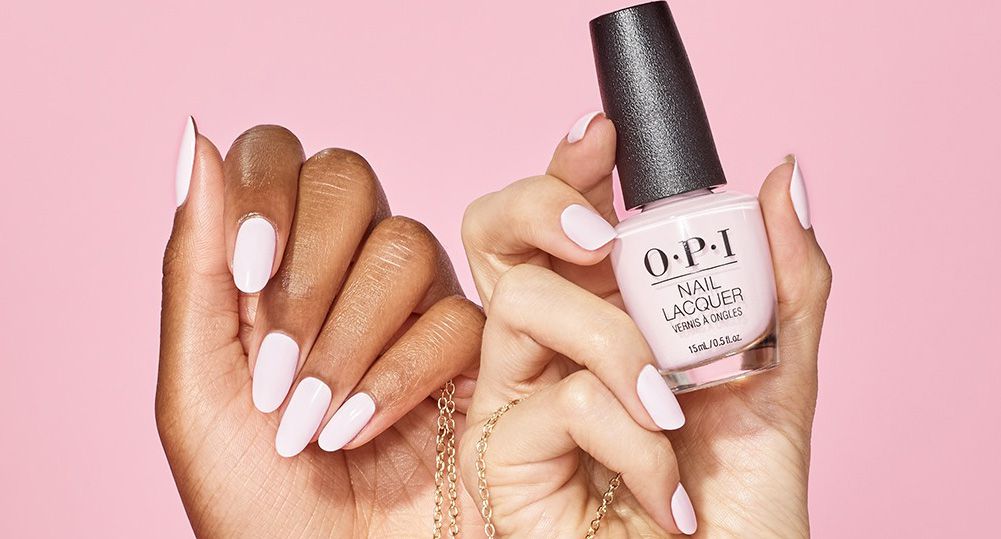 Hands of two black and white women holding opi nail polishes and a gold chain, Nail Lacquer vs. Gel Polish