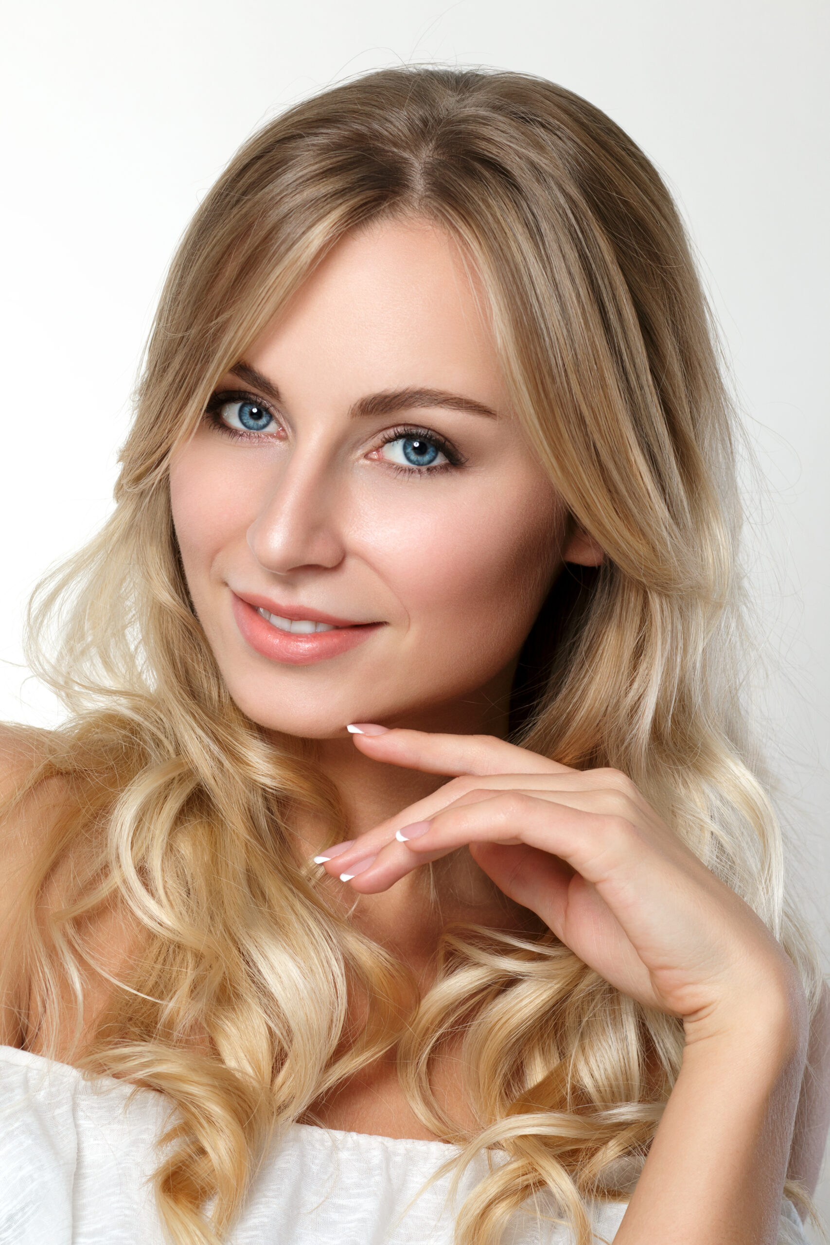 Portrait of beautiful blonde woman with blue eyes over white background. Skincare, spa, wellness and lifestyle concept. Studio shot.