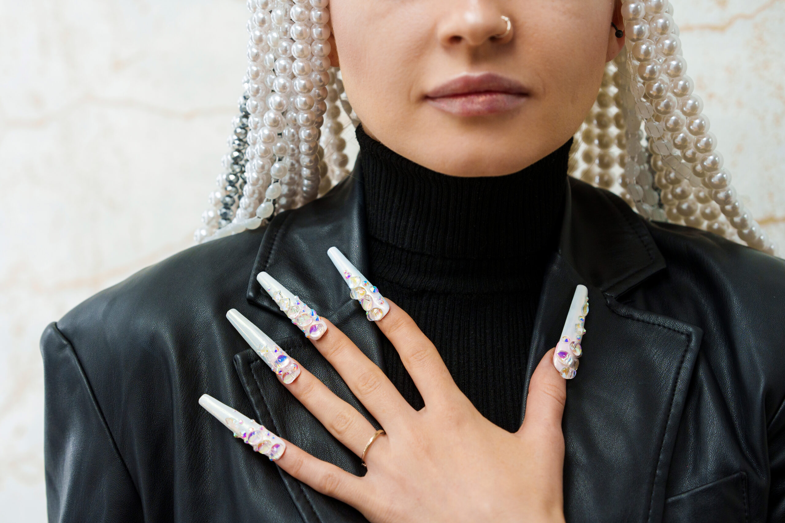 Cropped photo of a female artist showing long and decorated fake nails, Nail Art Designs