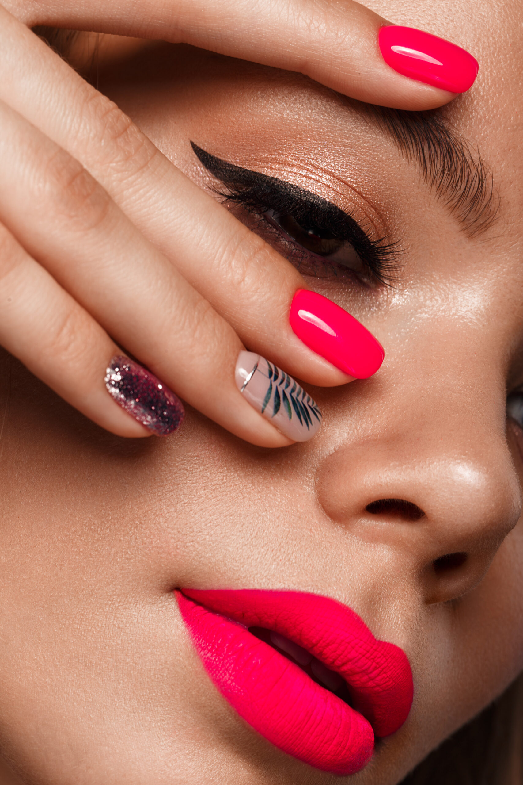 Beautiful young woman with bright makeup and neon pink nails. Beauty face. Photo taken in the studio. acrylic nail