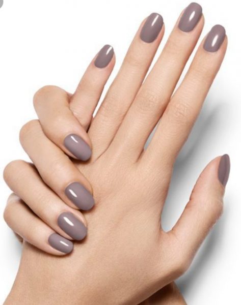 A woman's hands with painted nails in one of the Fall 2023 nail polish colors. fall 2023 nail colors