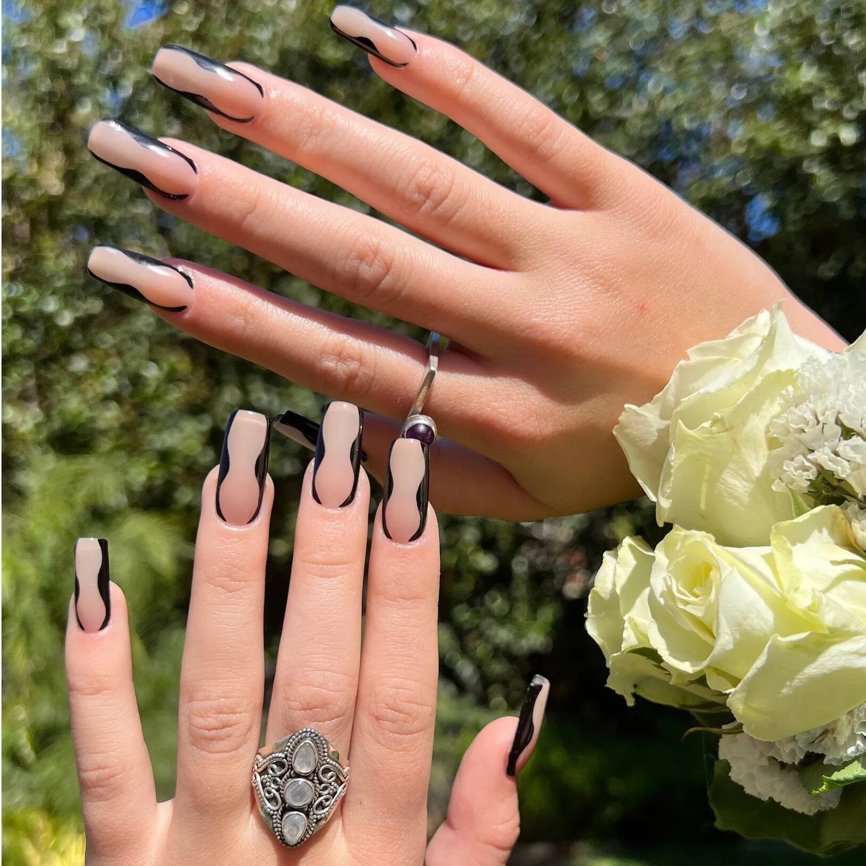 A woman's hands adorned with nude nail art and a ring. Nude Nails