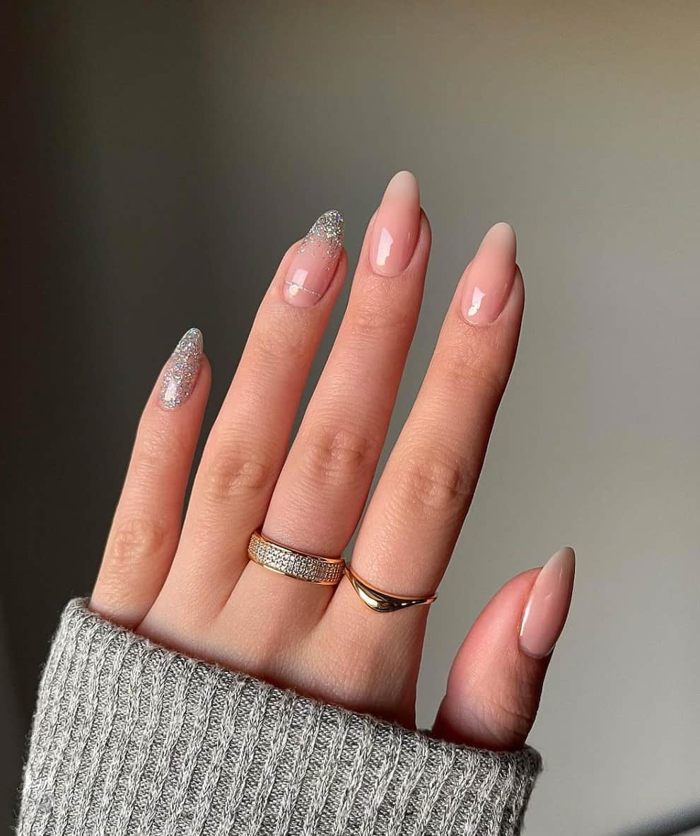 A woman's hand holding a sweater and a pair of nude nails. Nude Nails