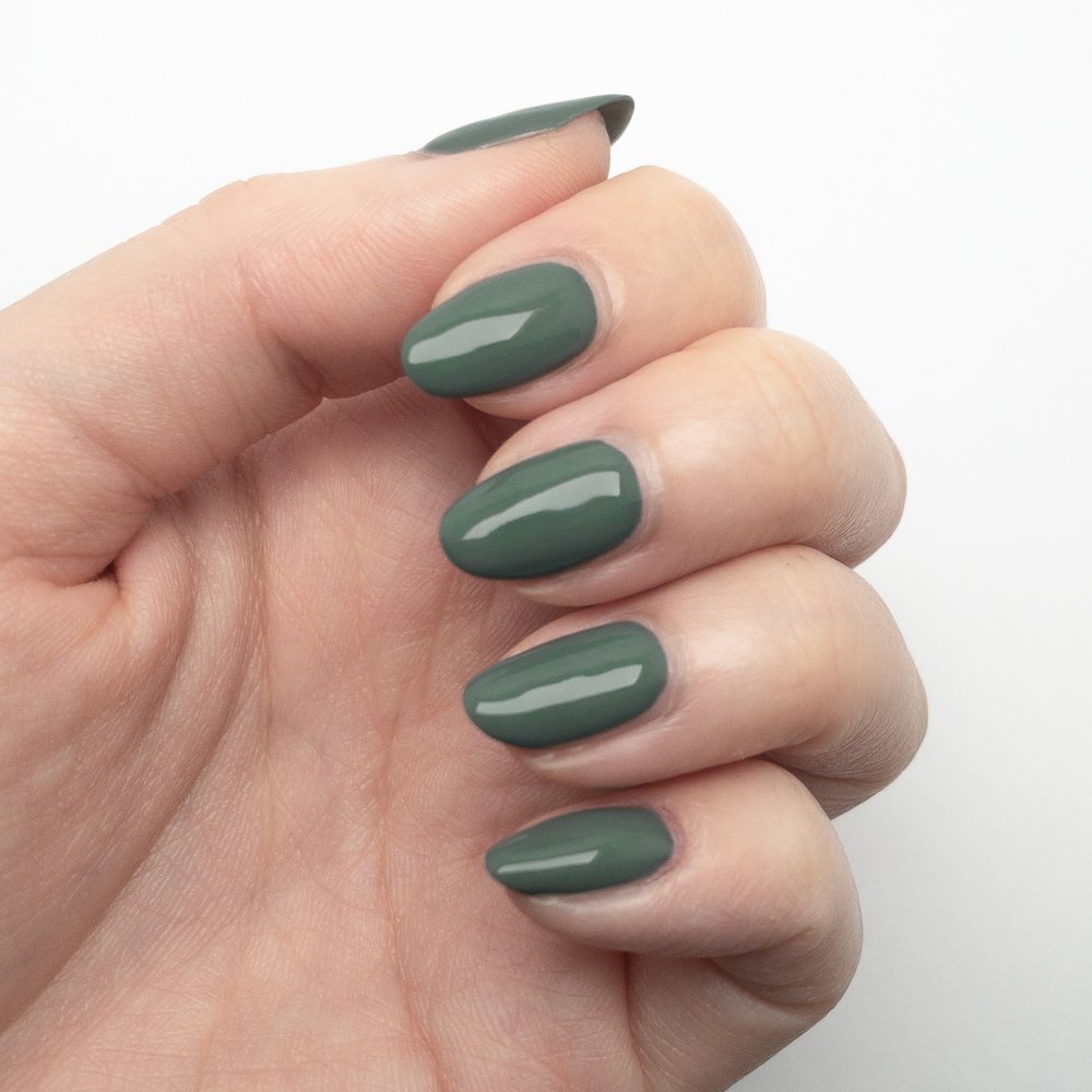 A woman nails with forest fern green nail polish shade painted on them