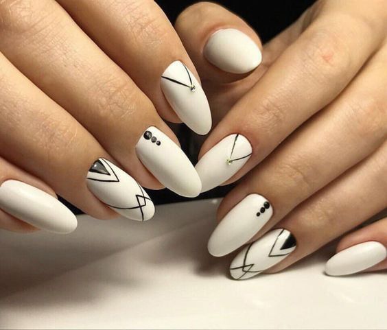 Woman's hands with white oval nails and geometric lines