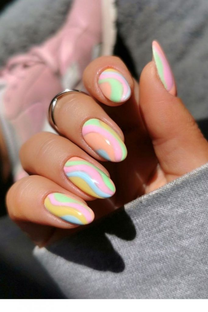 A woman's hand with round pink and white marbled nails