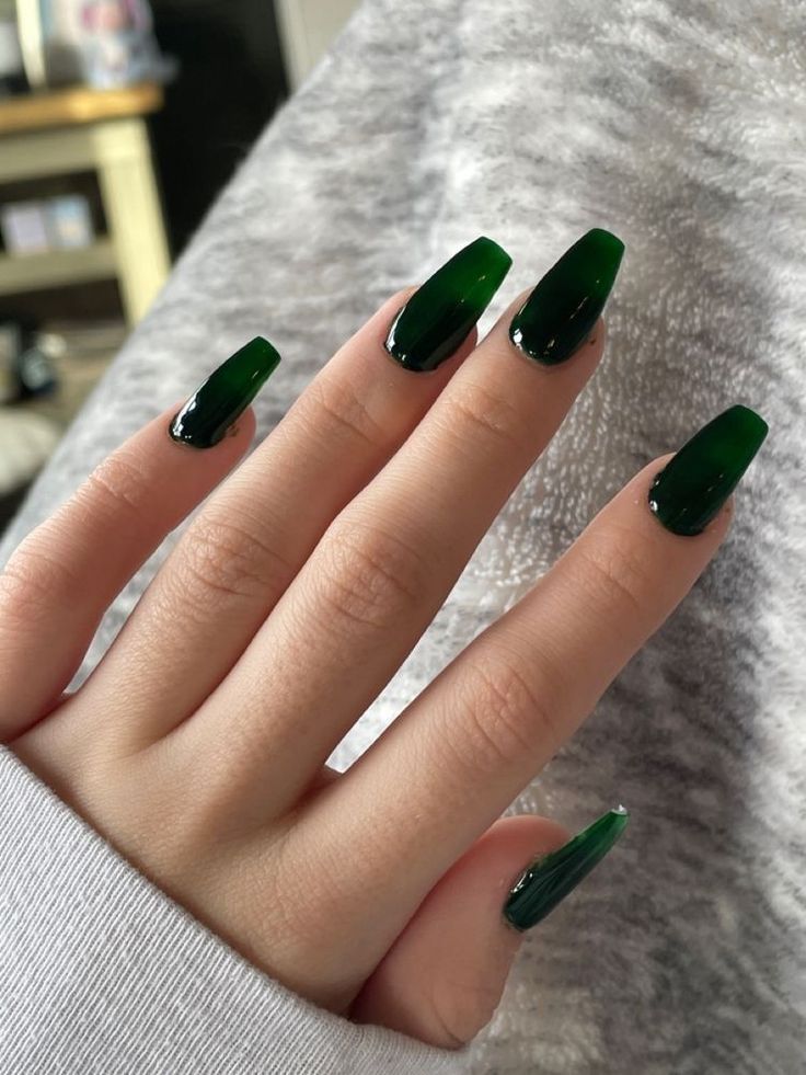 A woman's hand putting on a beautiful and attractive bold green manicure 