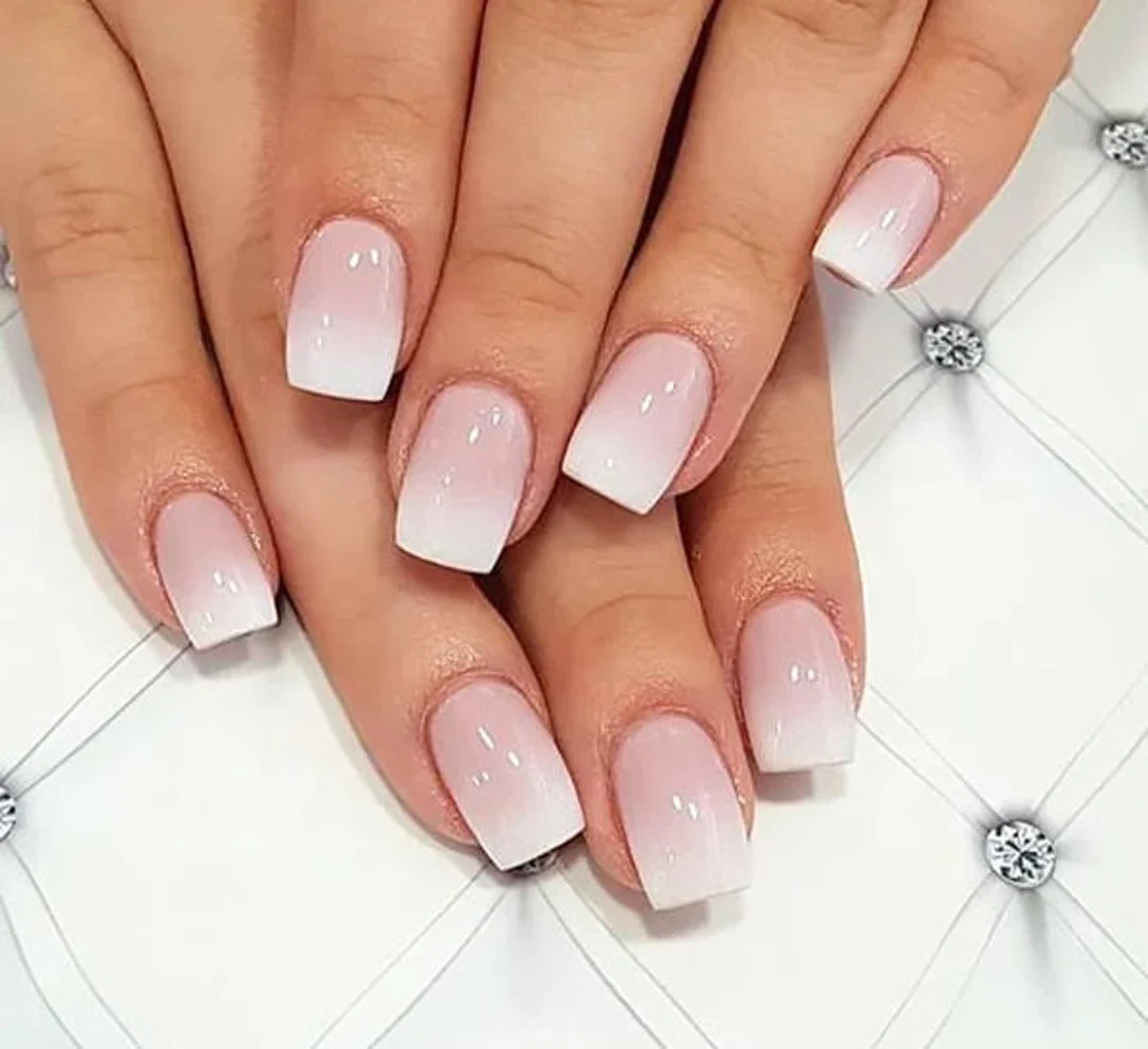 A woman's hands with Squoval Nails in pink and white with an amazing gradient between the two colors