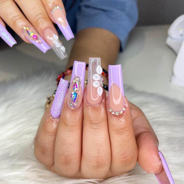 A woman's hand with lavender acrylic nails.