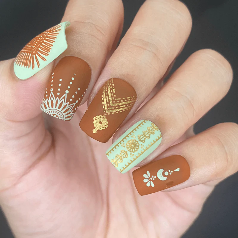 A person with brown nails adorned with designs.