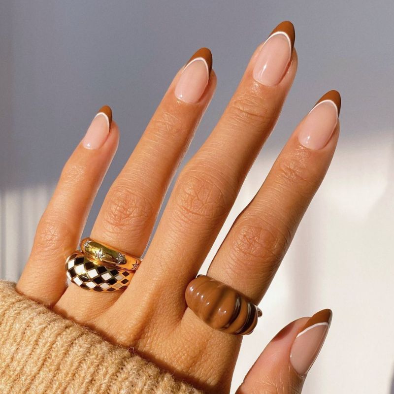 A woman's hand displaying a brown nail and ring. Brown Nail Art