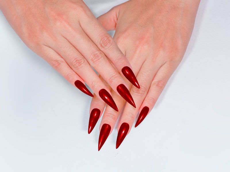 A woman's hand with stiletto nails in bright red