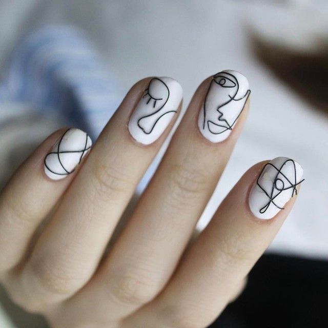 A woman's nails with abstract fall design in white and black