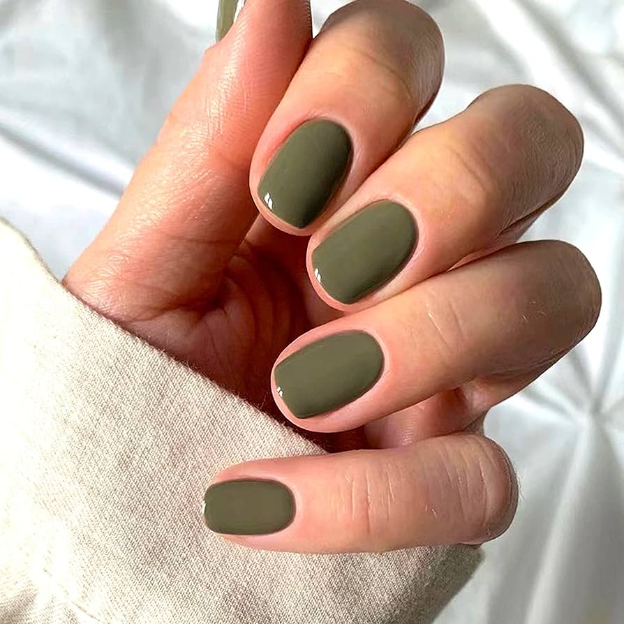 A woman's hands with a warm-toned olive green nails.