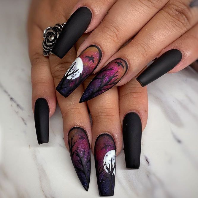 A faceless woman's nails with stiletto and coffin nails with Halloween nail designs. Fall Nail Designs