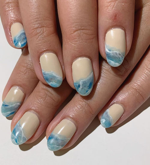 Woman's hand with nail polish on the beach and mood. Tropical nail designs