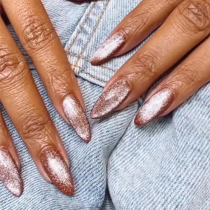 Faceless woman has nails painted with a glossy brown nail shade that suits the fall trends