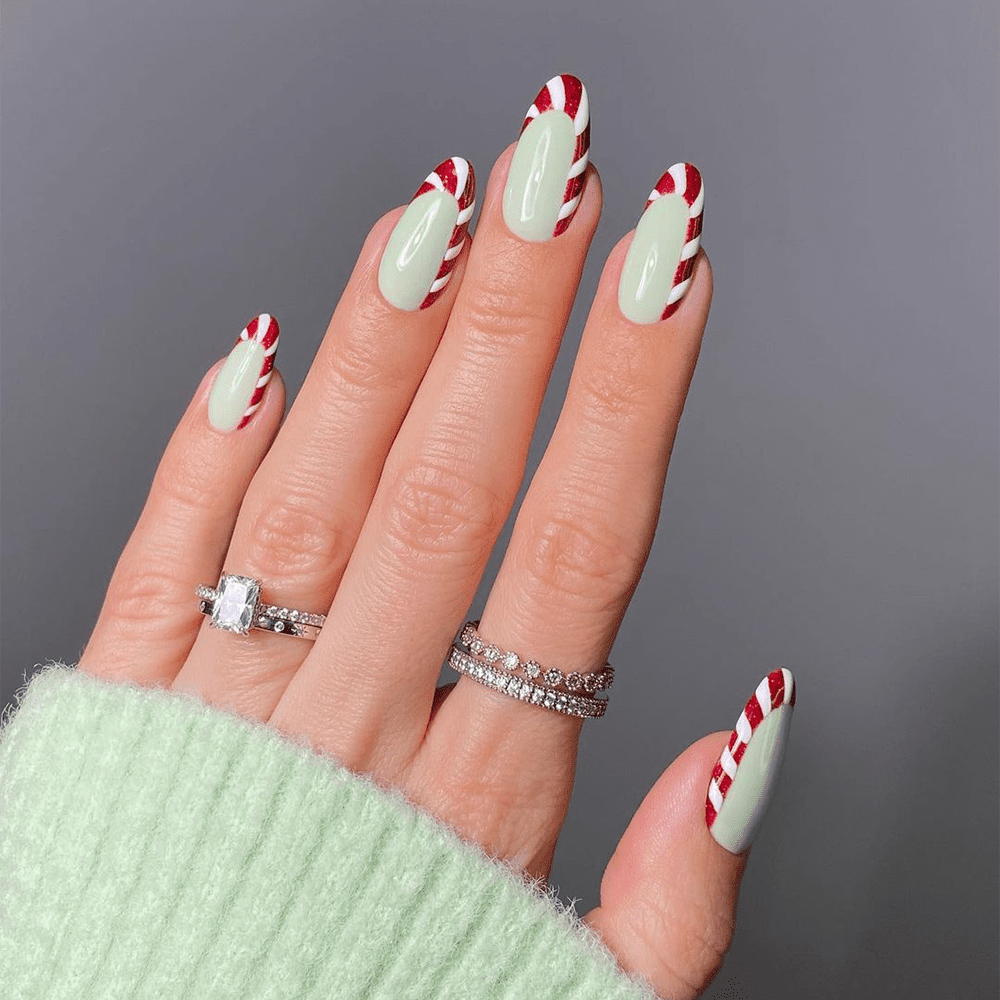 A woman wearing a green sweater with Christmas nail.