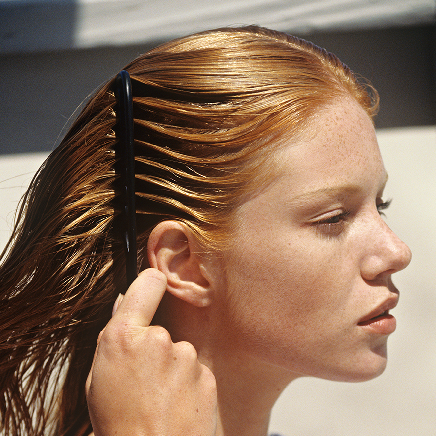 A woman is styling her hair. DIY Hair Coloring