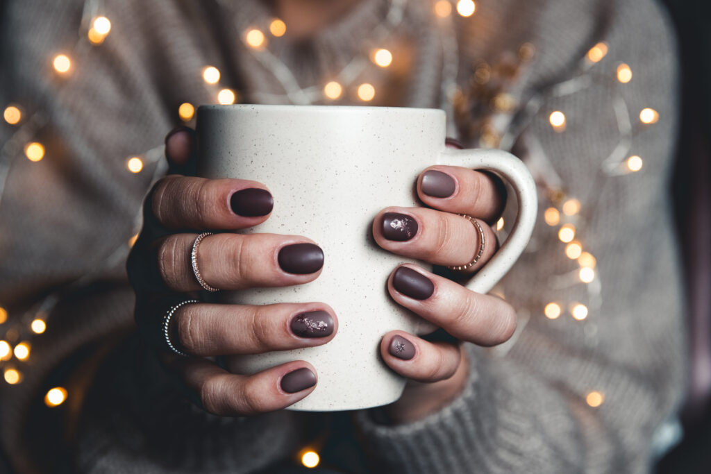 cup-with-cocoa-and-marshmallow-in-the-hands-of-the-2021-12-09