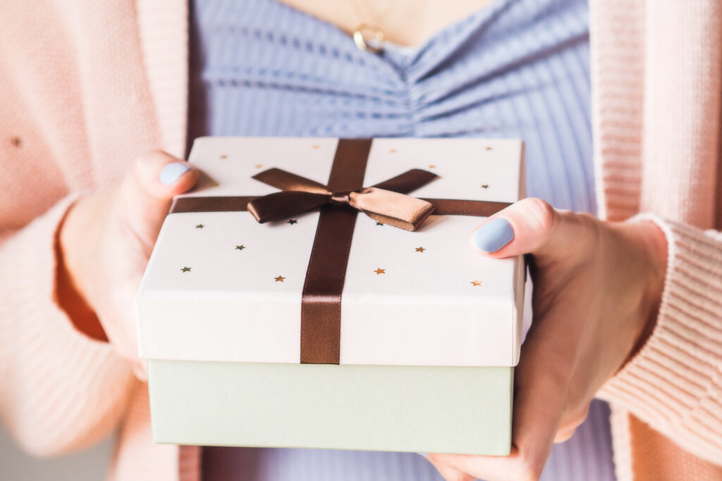 woman-holding-gift-box-with-bow-pastel-2021-08-30