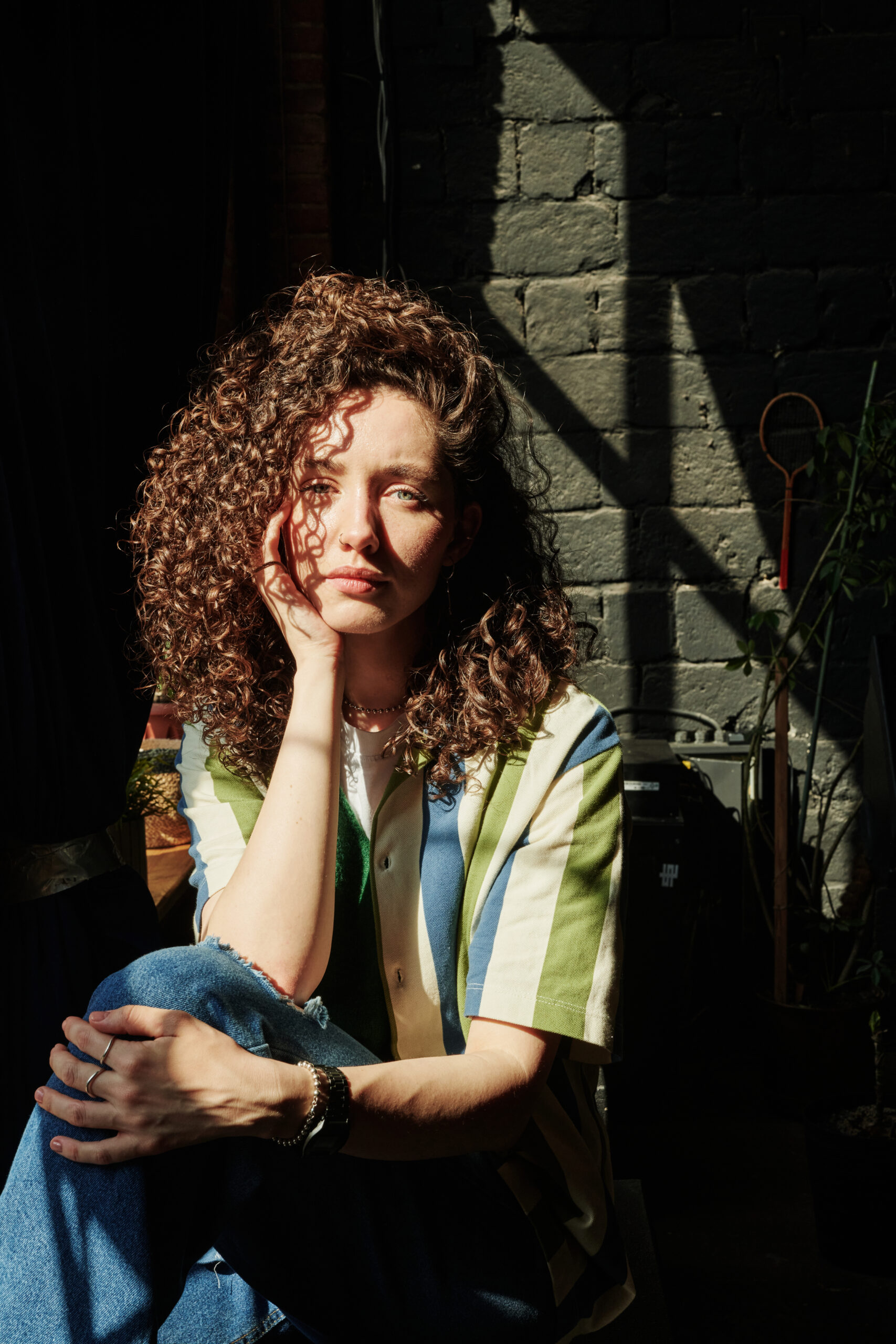 young-serene-female-with-curly-brown-hair-keeping-2022-06-15