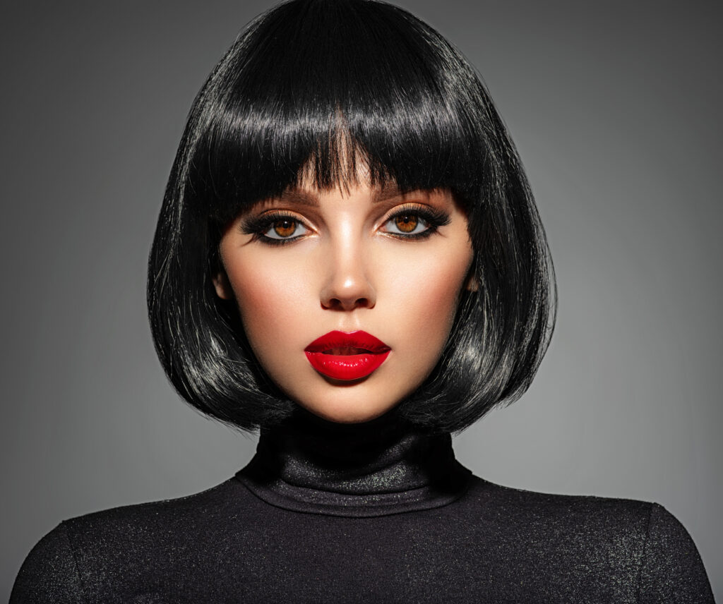 Beautiful brunette girl with red lips and black bob hairstyle. Pretty young woman with black hair. Closeup portrait of a model with bright makeup on a face. Fashion portrait of a pretty lady. 2024 hair trends