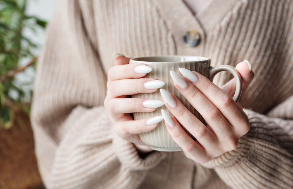 hands-of-a-young-woman-with-white-manicure-on-nail-2023-11-27