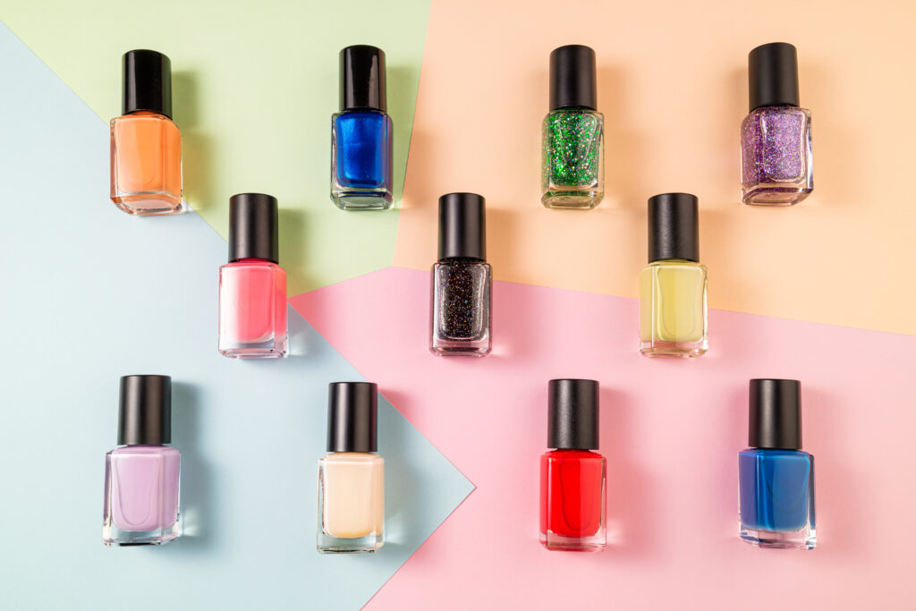 Pattern of various nail polish bottle on color background. Stylish trendy nail polish for female manicure. Set of colorful nail polish top view. summer 2023 nails