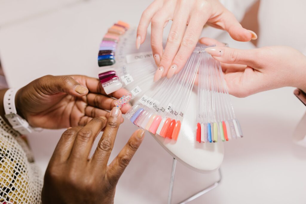 Woman Choosing Color From Nail Polish Palette İn Beauty Salon for her ombre nails