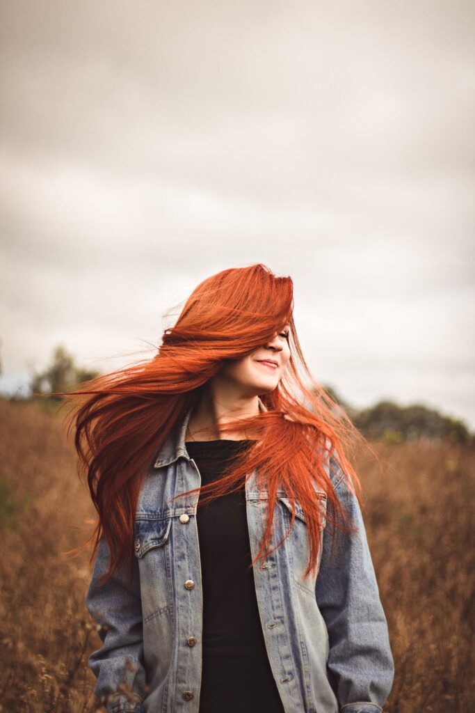 A beautiful smiling woman with long, straight red hair. A hair trend for 2024