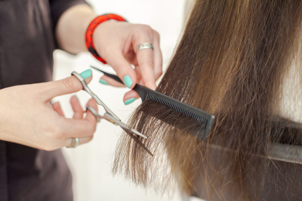 Woman does a haircut, layered haircut at home. 2024 hair trends