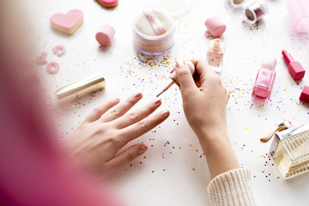 Woman with pink hair doing ombre nails at home
