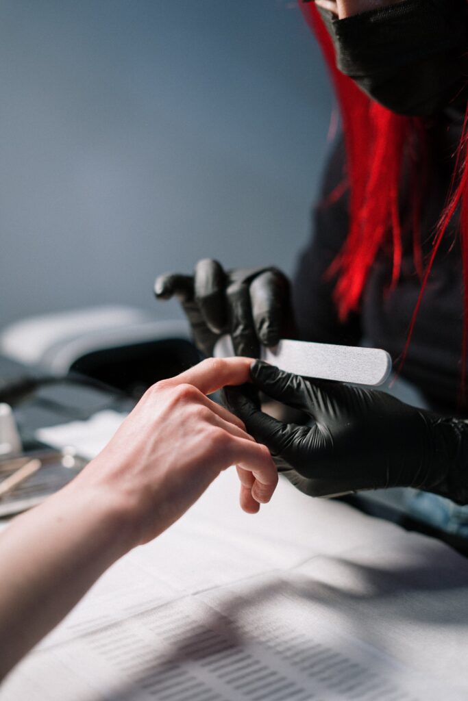 A girl is doing her nails at a nail salon by a professional nail technician. nail services