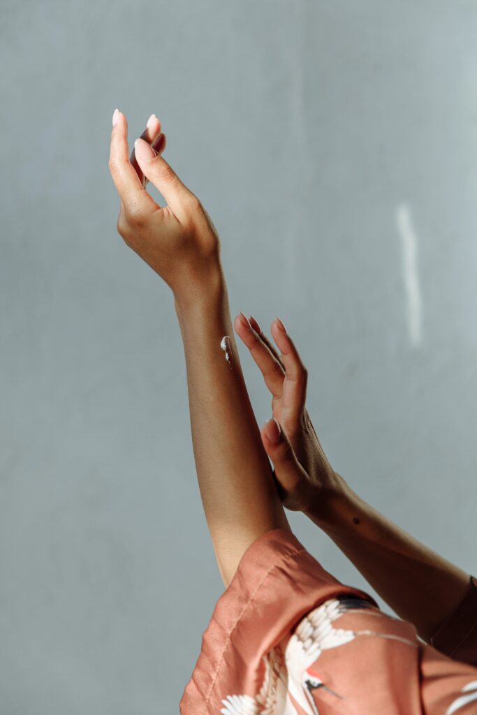 A faceless woman applying a hand cream after removing her hair by soft wax