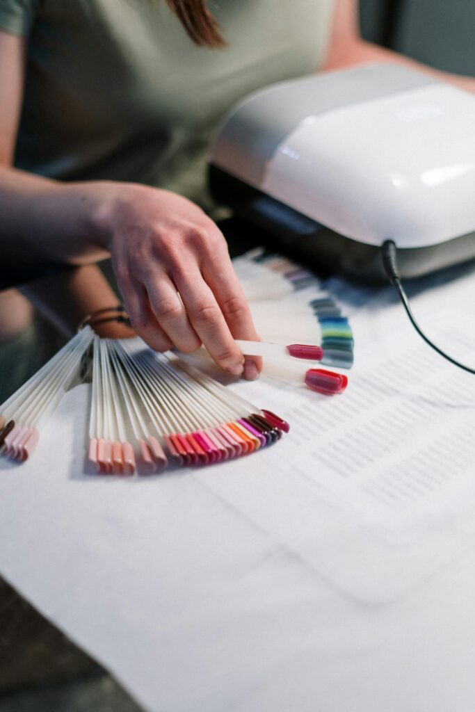 A woman's hand chooses a color for gel polish from a range of colours