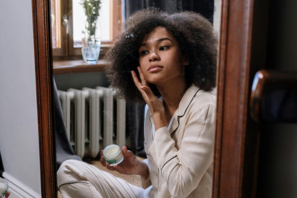 A girl with curly hair is doing her morning face care routine