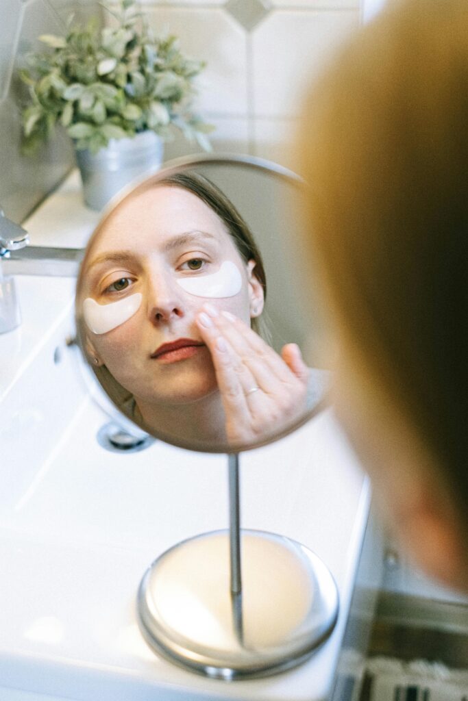 a woman is doing her eye care routine, morning skincare and applying eye mask