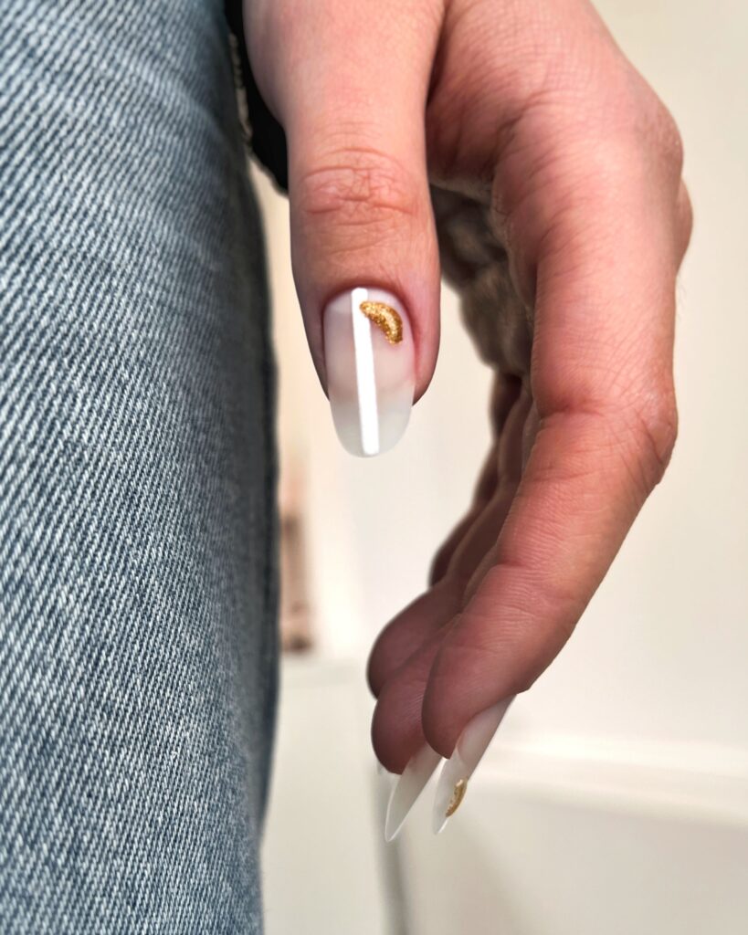 A closeup image of a female hand with professionally painted nails in natural tones. nail tips