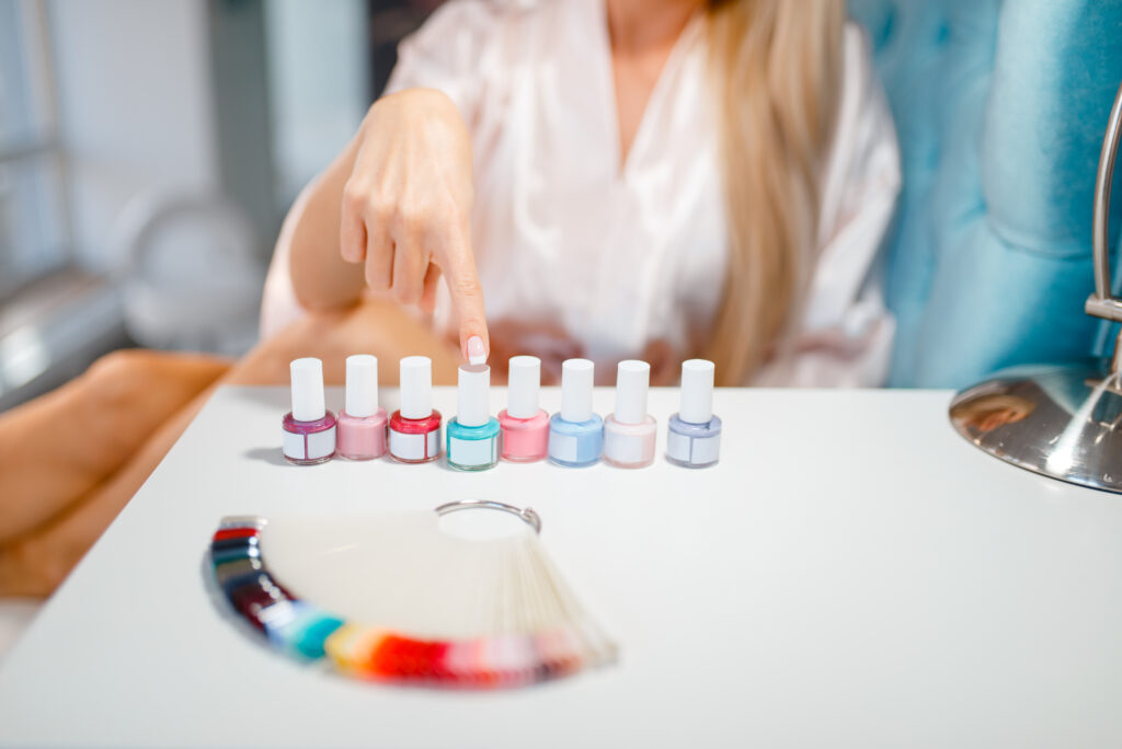 Color Changing Gel Polish. Female customer choosing nail varnish in beauty shop. Professional manicure and pedicure service, hands and legs treatment, client in beautician salon, woman at the manicurist. Home manicure.