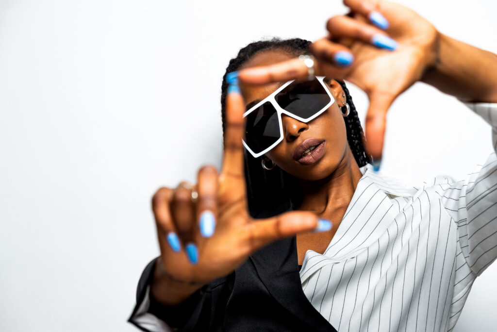 Beautiful afro-american woman with afro pigtails hairstyle and stylish clothes - Portrait of young black girl in studio. nail polish. nail polish shades