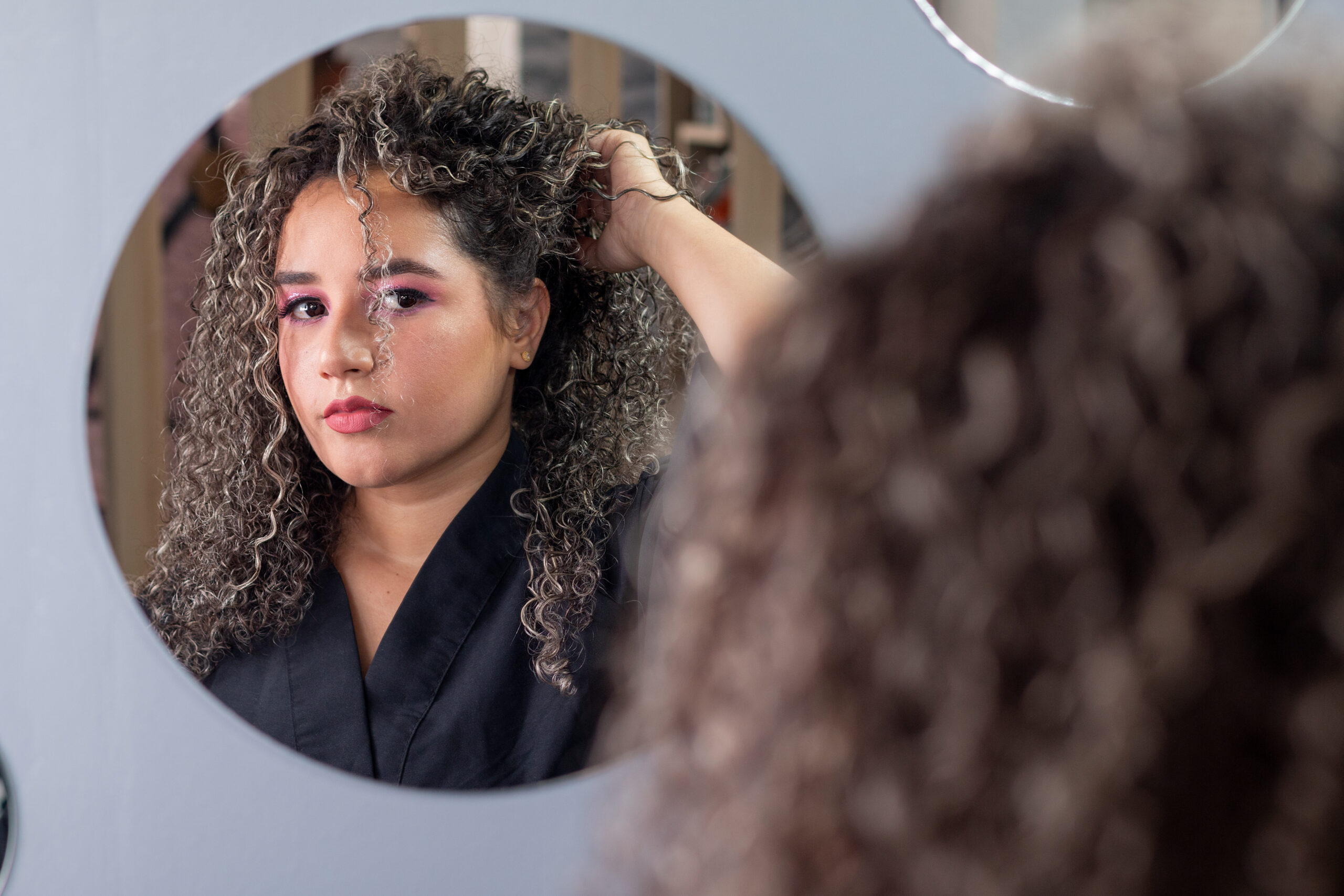 Hair PErm. Home Hair perm. DIY hair perm. Beautiful woman with curly hair, poses and changes her hairstyle while looking in the mirror.