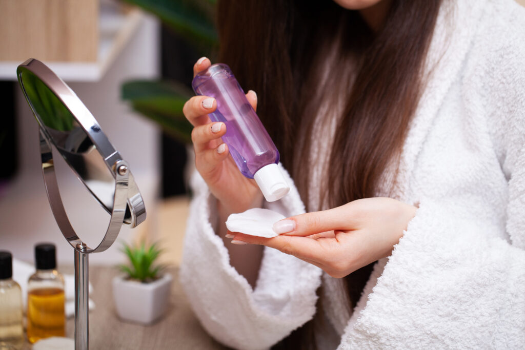 Micellar Water. Close up girl puts makeup remover for removing her makeup.