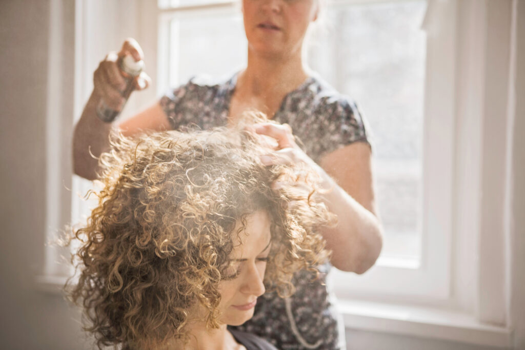 Hair stylist working on hair client. perm hair. home curly hair. DIY perm hair