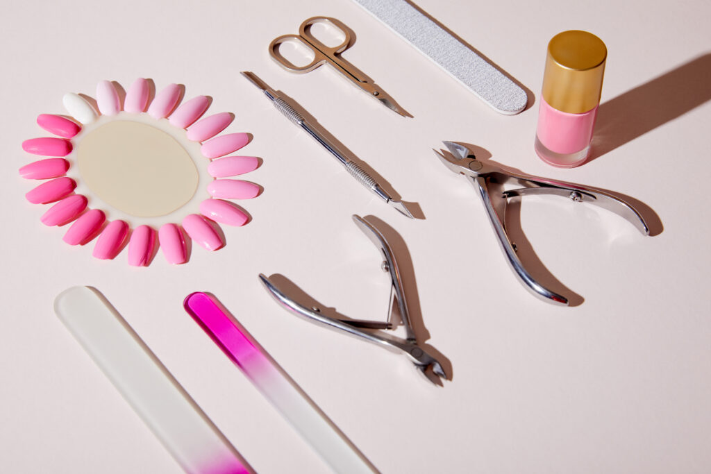 Essential Nail Tools and Supplies. High angle view of bottle and samples of nail polish near manicure instruments on white background. all needed to apply home nail polish and easy DIY designs.