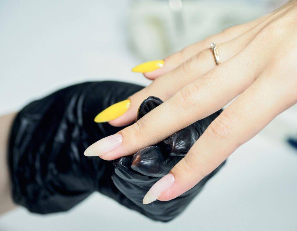 a faceless woman with long painted yellow and white shades. nail polish for fair skin