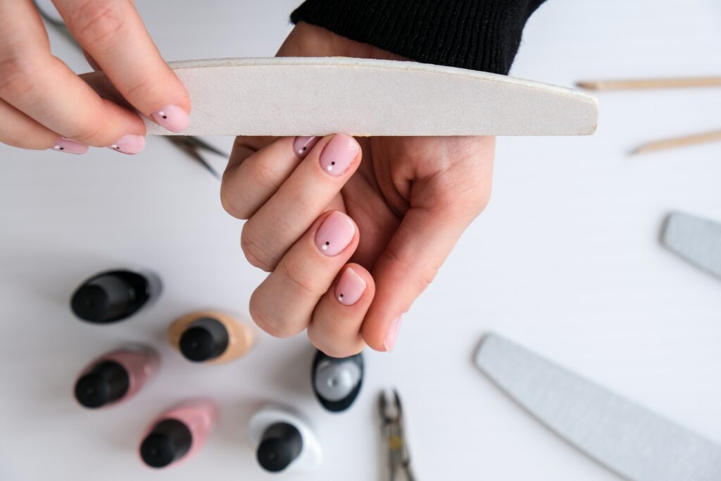 woman's hands doing nail polish manicures and buffing her nails