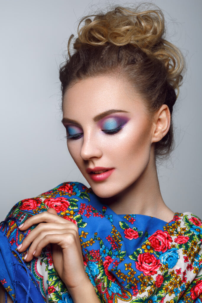 beautiful girl with bright colorful makeup in russian traditional shawl. studio beauty shot. copy space.