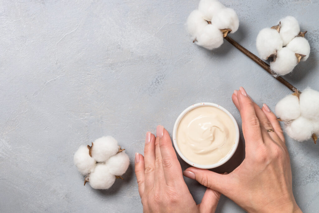 Skin Type Considerations. Clay mask and cotton flowers on stone background top view. skin care. body care. body home care