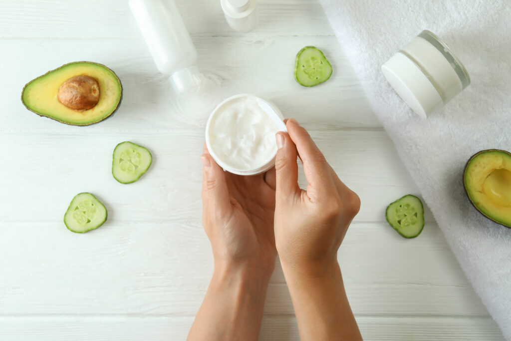 Female hands and natural spa cosmetics on white wooden table. body butter product. body care